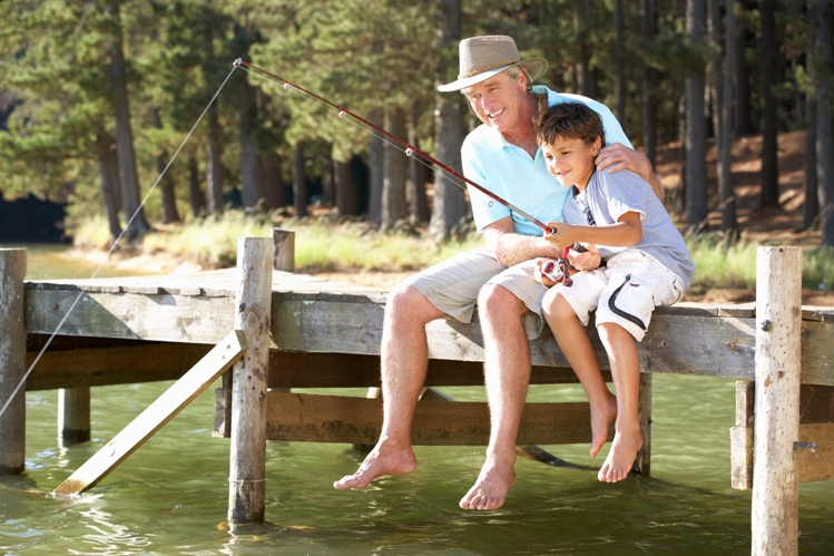 Photo of man and young child fishing on a dock.